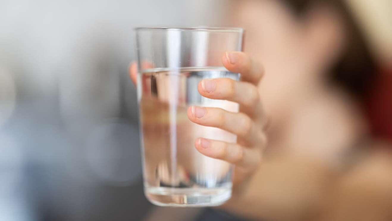 Frau hält Wasserglas