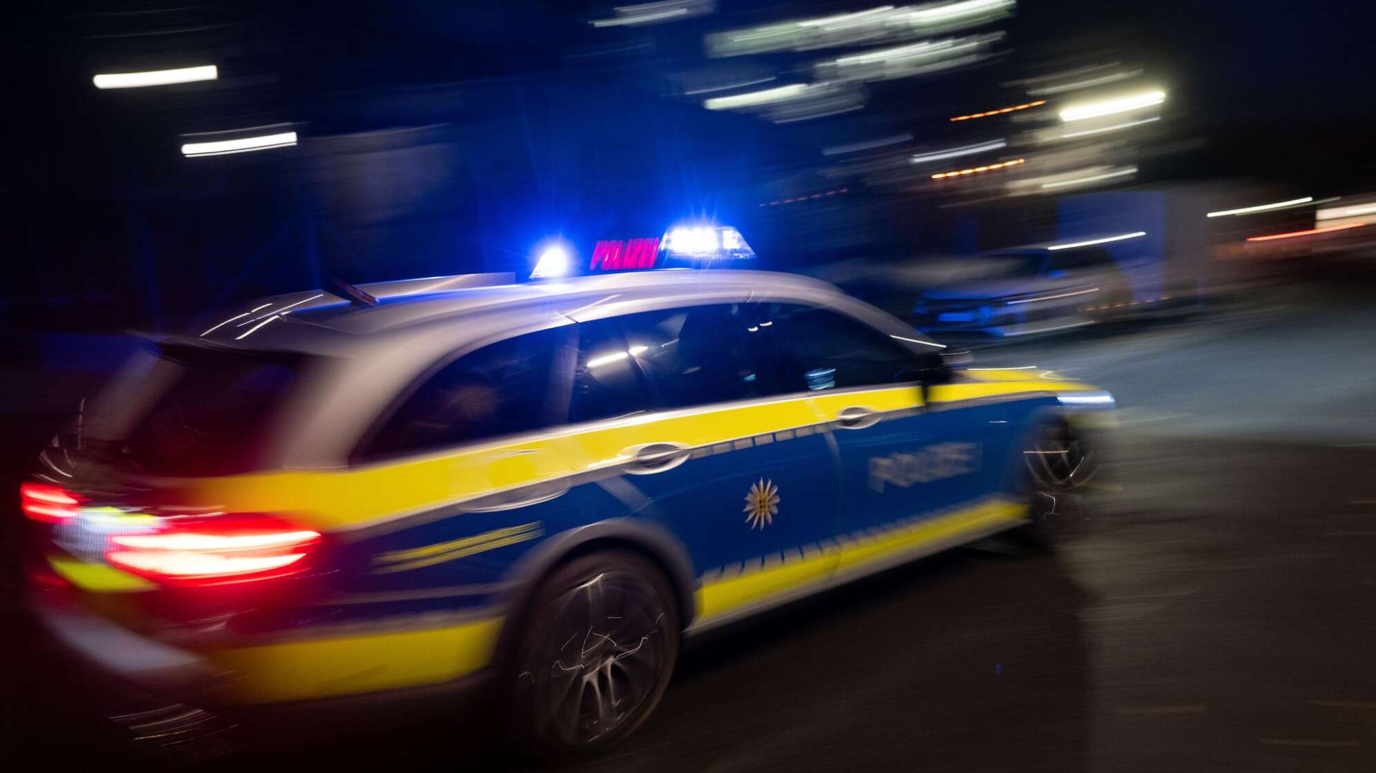 Ein Polizeiauto fährt mit Blaulicht zum Einsatz.