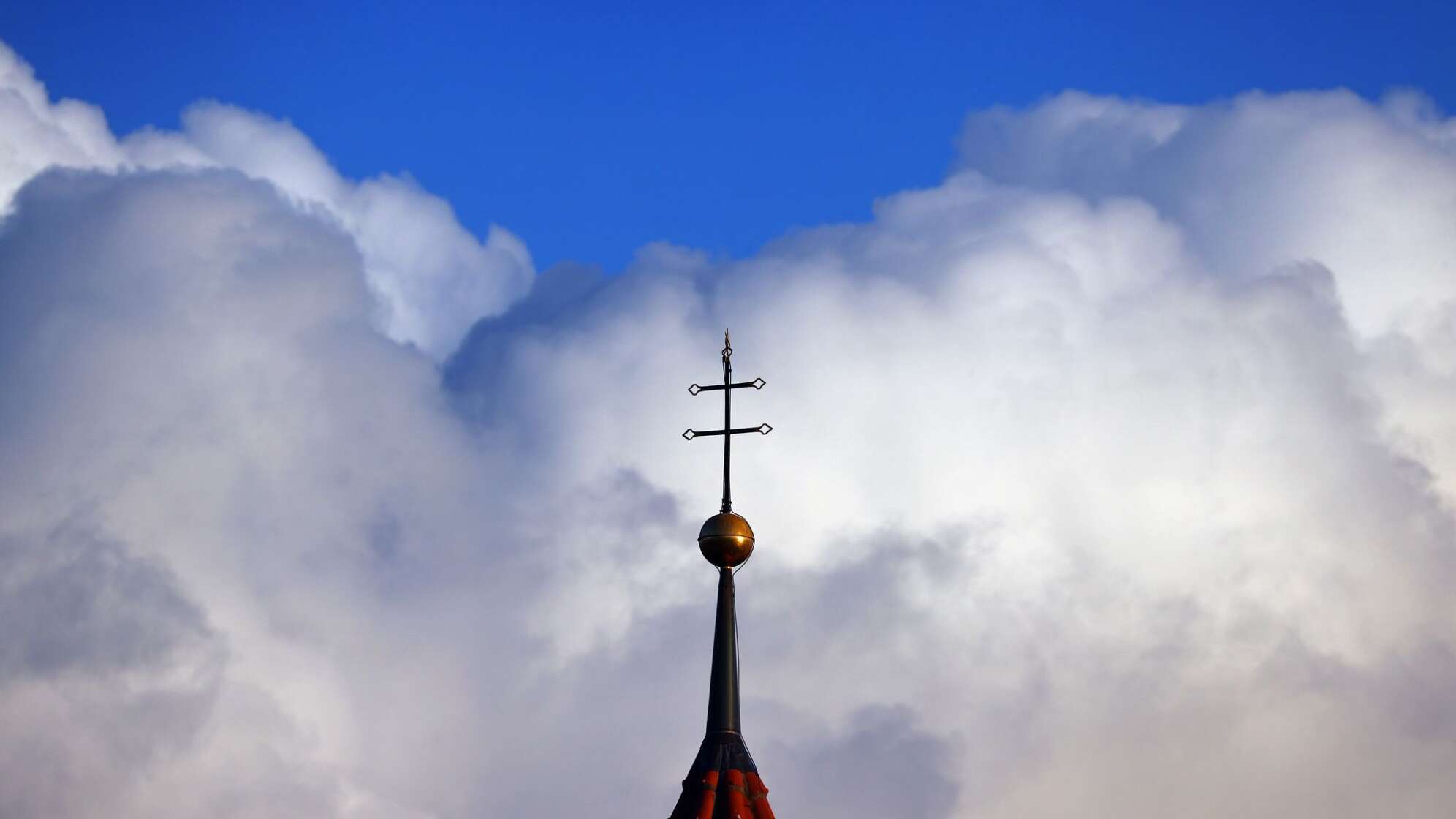 Wolken türmen sich über Kirchturm