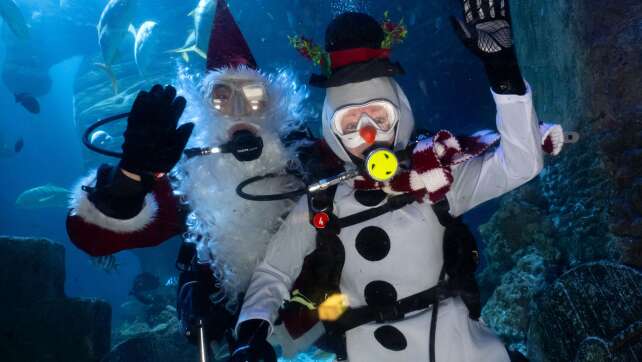 Weihnachtsmann verteilt Geschenke unter Wasser